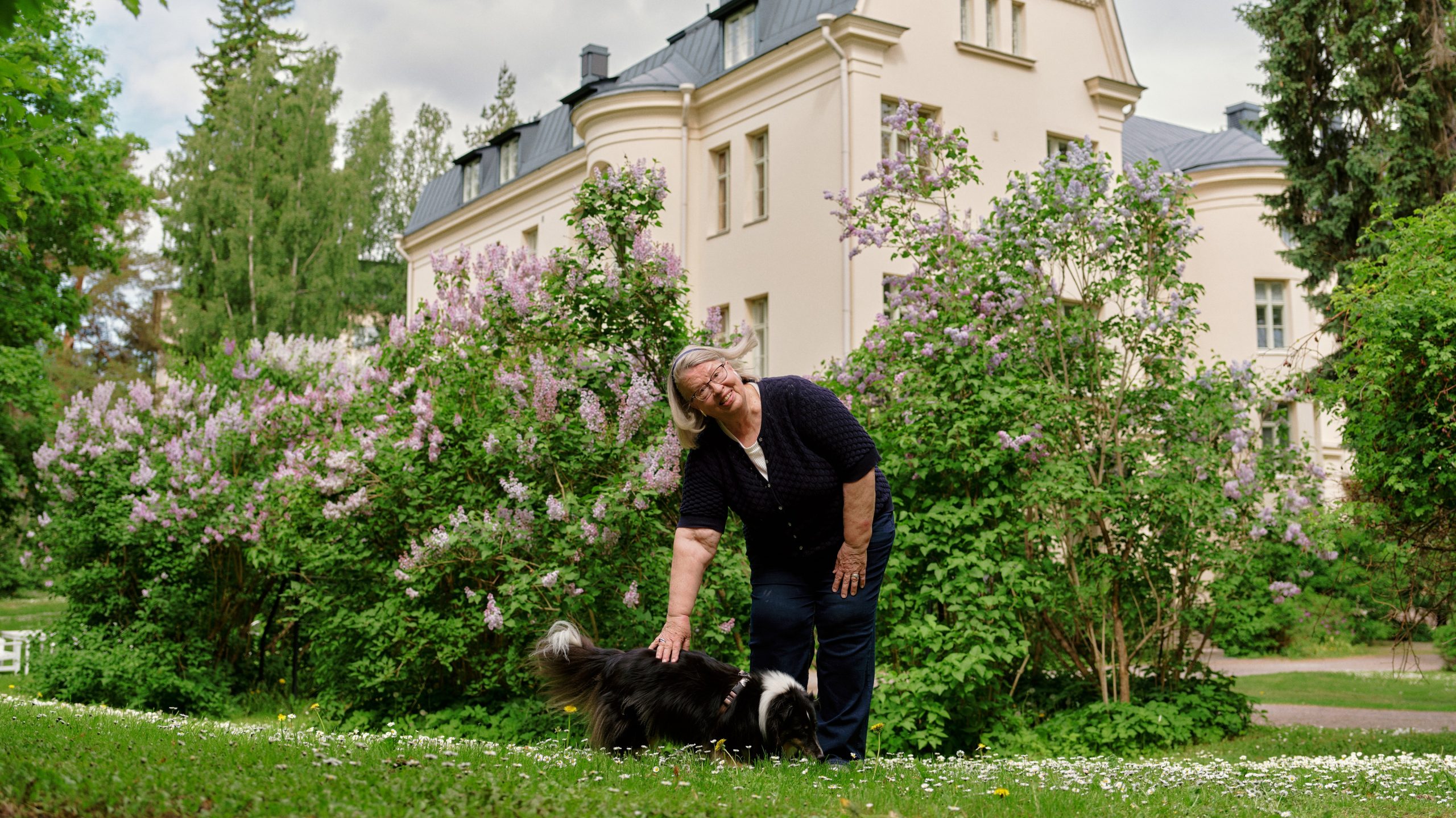 Riitta Nissinen och hennes hund rastar i den grönskande Östanåparken.